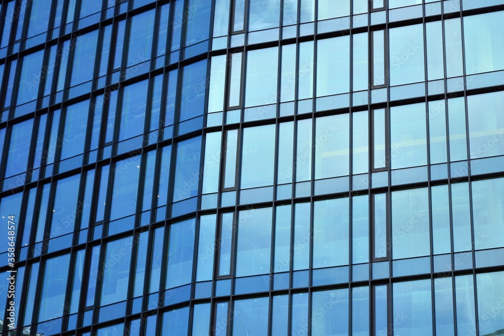 Facade texture of a glass mirrored office building. Fragment of the facade. Modern architecture of the office building. Facade texture of a glass mirrored office building. Fragment of the facade. Modern architecture of the office building.