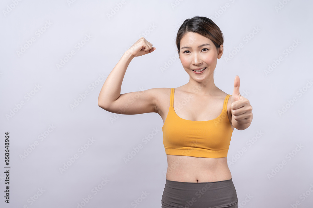 Portrait of Asian sporty woman giving thumb up isolated on white background. concept of healthy lifestyle Portrait of Asian sporty woman giving thumb up isolated on white background. concept of healthy lifestyle