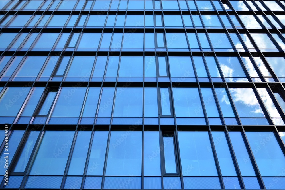 Facade texture of a glass mirrored office building. Fragment of the facade. Modern architecture of the office building. Facade texture of a glass mirrored office building. Fragment of the facade. Modern architecture of the office building.