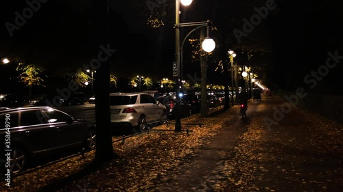 Cyclists riding on his bikes on cycle lane in Berlin / Tiergarten / Strasse des 17. Juni towards Branderburg Gate at beautiful autumn night