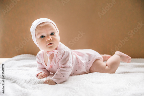 Infant baby two-month old learns to roll over on his stomach. Psychomotor development and baby care photo