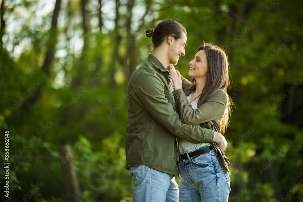 Happy young couple hugging and laughing outdoors in the park Happy young couple hugging and laughing outdoors in the park
