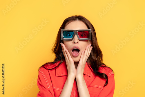 surprised young woman in 3d glasses isolated on yellow