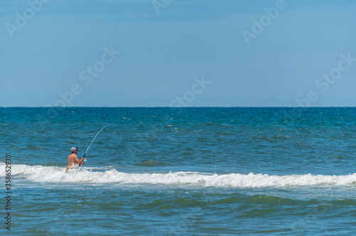Man Surf Fishing in Water at Beach © Tom Ramsey
