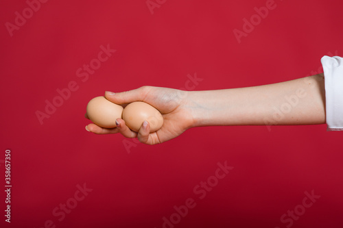 Woman holding eggs in hand with eggs on pink background, copy space. Healthy food concept. Top view, flat lay. Easter eggs. Happy Easter concept