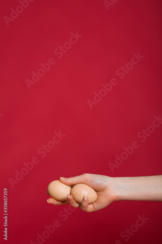 Woman holding eggs in hand with eggs on pink background  copy space. Healthy food concept. Top view  flat lay. Easter eggs. Happy Easter concept