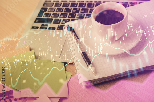 Double exposure of forex chart drawing and desktop with coffee and items on table background. Concept of financial market trading