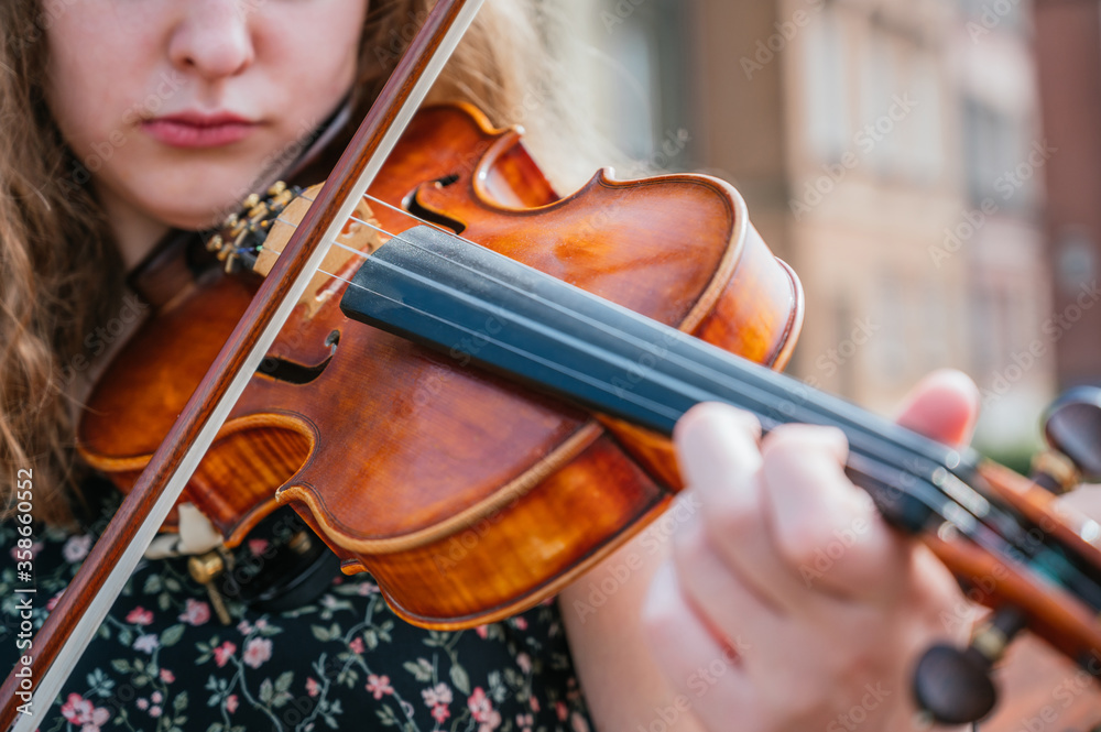 Young woman playing the violin outdoors Young woman playing the violin outdoors