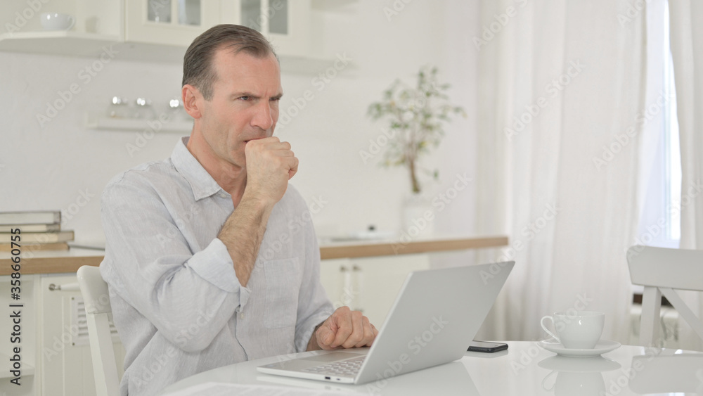 Naklejka premium Sick Middle Aged Man with Laptop Coughing at Home