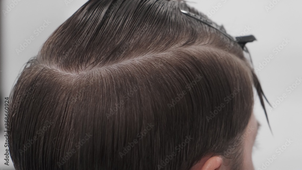 Professional female hairstylist combing man hair. Hairdresser working in salon Professional female hairstylist combing man hair. Hairdresser working in salon
