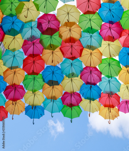 Colourful sun umbrellas against the blue sky. Street decoration. 