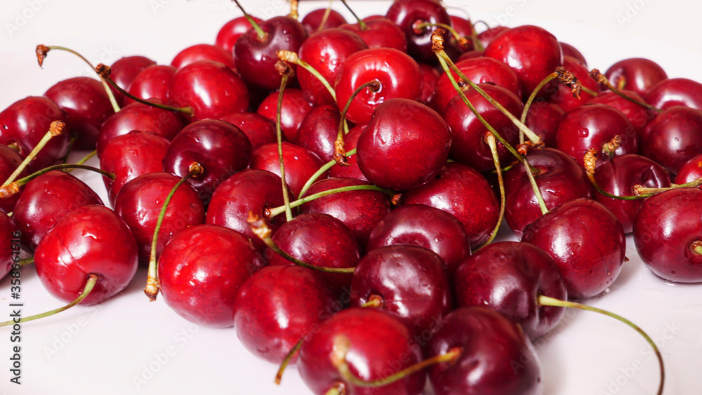 Selective focus image. A lot of fresh sweet cherry fruit berries with water drops. Close-up on the white background. Large collection of fresh red cherries. Ripe cherries texture Selective focus image. A lot of fresh sweet cherry fruit berries with water drops. Close-up on the white background. Large collection of fresh red cherries. Ripe cherries texture