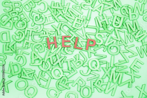 Help needed with word blindness dyslexia - lime green alphabet letters randomly scattered with brown letters spelling HELP in the middle with plenty of copy space around
