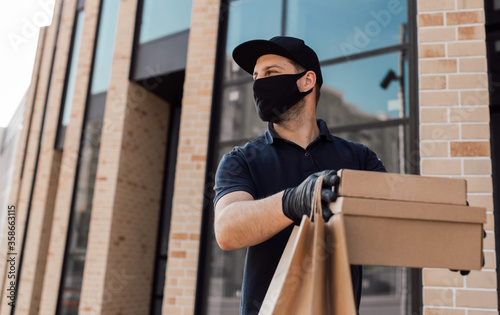 Courier in protective mask and medical gloves delivers takeaway food