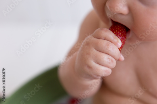 a small child eats strawberries. strawberry in a small child's hand