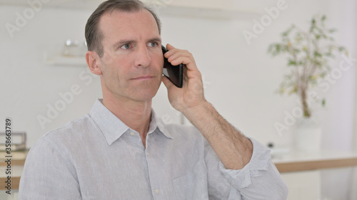 Close Up of Middle Aged Man Talking on Smartphone