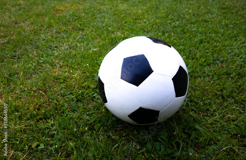 Children's soccer ball white on the green grass