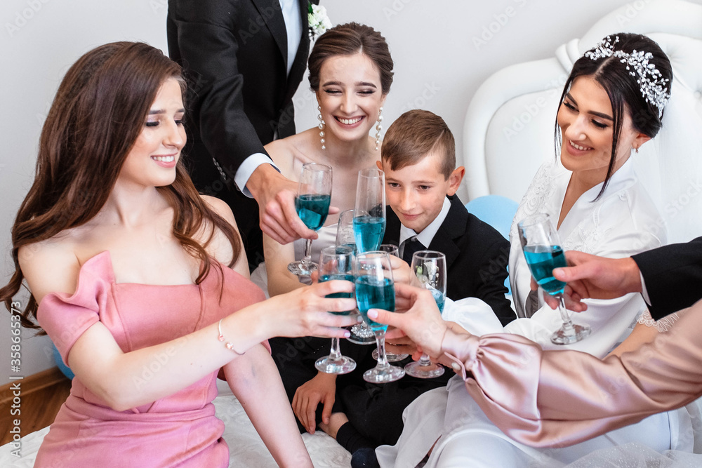 Close up photo of smiling women and men drinking champagne. Wedding. Glasses of champagne. We drink for the bride. General photo. Close up photo of family.