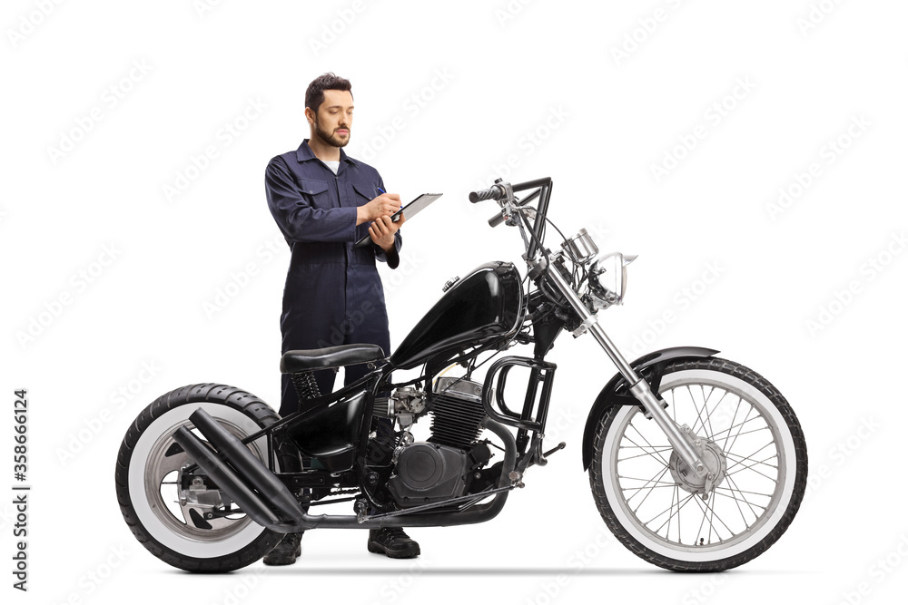 Motorcycle mechanic in a uniform writing a document for a chopper motorbike