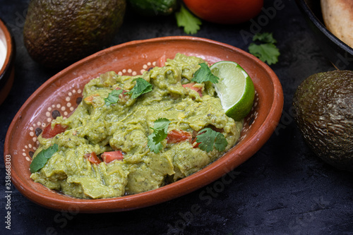 Authentic Mexican guacamole in traditional clay dish
