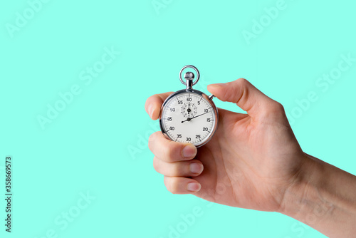 stopwatch hold in hand, button pressed, aqua menthe background