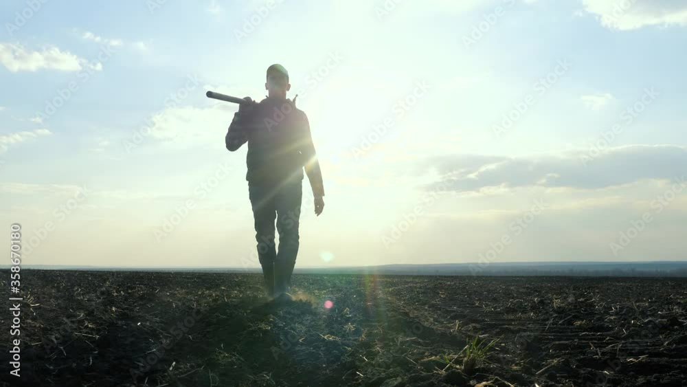 man farmer silhouette red neck holding a shovel in his hand walking across the field a pile of dirt soil. Eco lifestyle smart agriculture land farming concept. worker agronomist with a shovel goes to man farmer silhouette red neck holding a shovel in his hand walking across the field a pile of dirt soil. Eco lifestyle smart agriculture land farming concept. worker agronomist with a shovel goes to