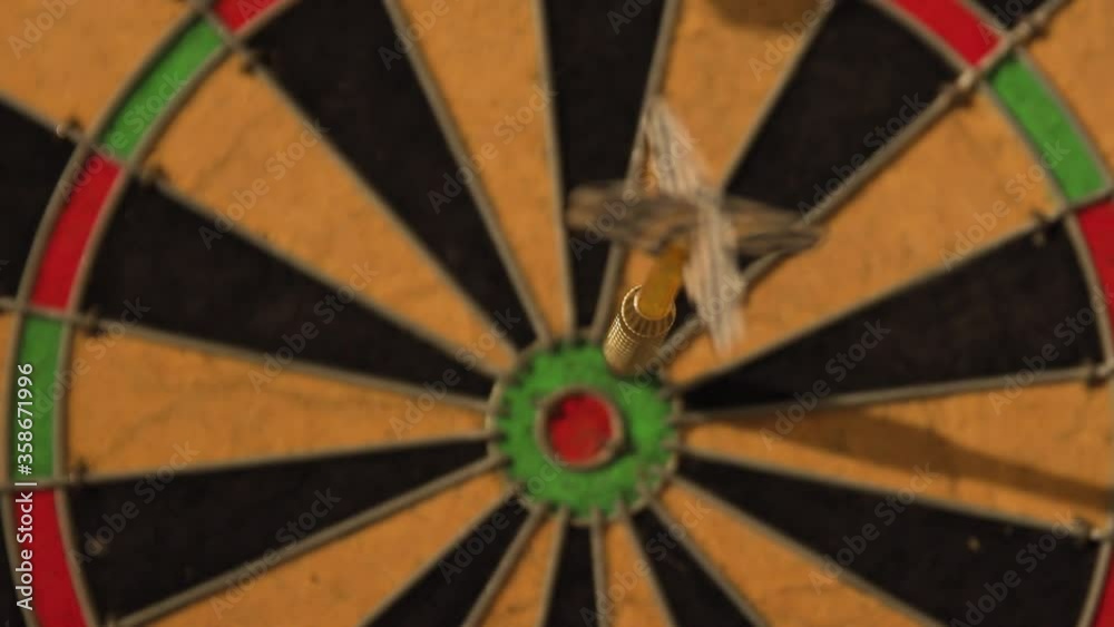Single dart stuck in the green outer bullseye of dartboard, close up, rack focus Single dart stuck in the green outer bullseye of dartboard, close up, rack focus