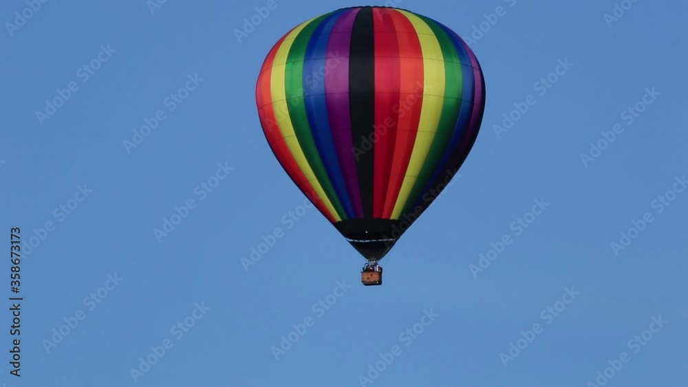 Rainbow hot air balloon floats across screen to left fires tank duck flies by blue sky background Rainbow hot air balloon floats across screen to left fires tank duck flies by blue sky background