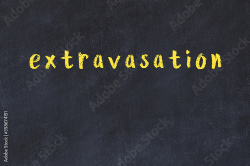 College chalk desk with the word extravasation written on in photo