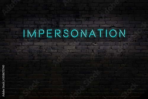 Neon sign. Word impersonation against brick wall. Night view photo