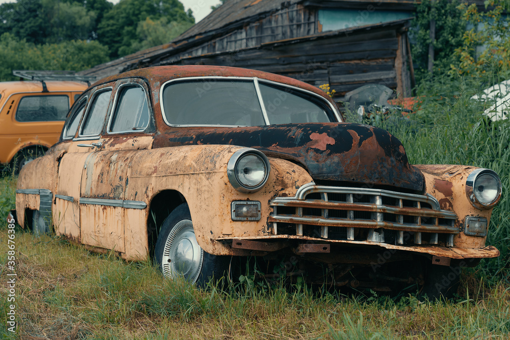 Fototapeta premium Old abandoned and forgotten rusty vintage retro car in bad condition.