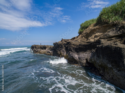 Waves from the ocean to the rock cliffs of the beach on the coast of Bali.