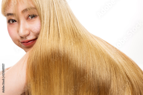 女性の金髪の髪の毛は輝いている。