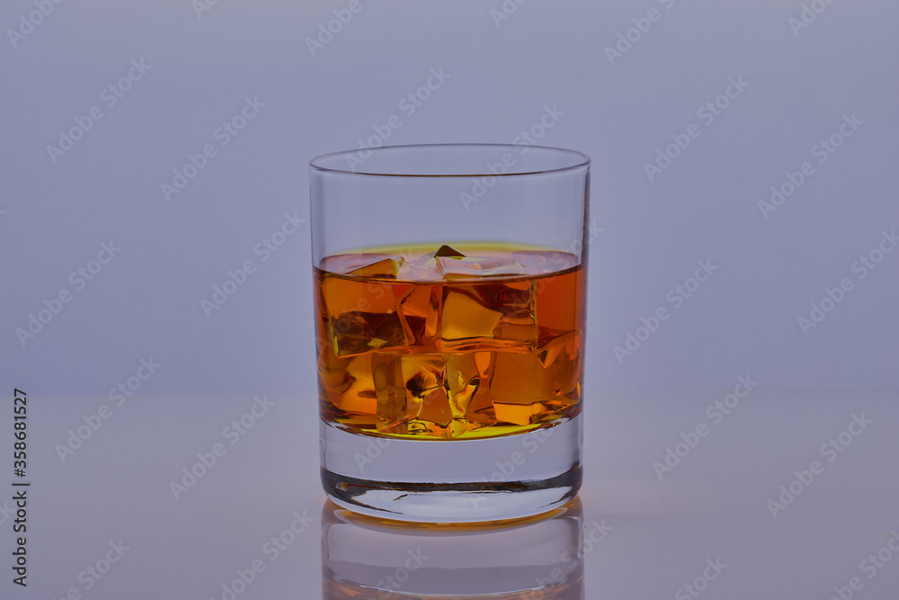 Glass of whisky with ice shot isolated on a white surface. Glass of whisky with ice shot isolated on a white surface.