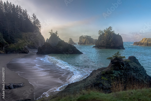Morning mist over silhouetted rocky shoreline. Location is Samuel Boardman State Park in Oregon, USA photo