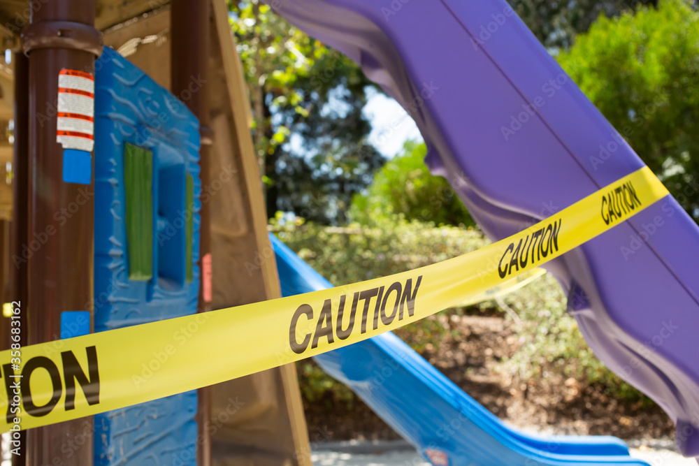 A view of caution tape wrapped around a slide, part of a playground area, during the Covid-19 pandemic, seen in Los Angeles, California. A view of caution tape wrapped around a slide, part of a playground area, during the Covid-19 pandemic, seen in Los Angeles, California.