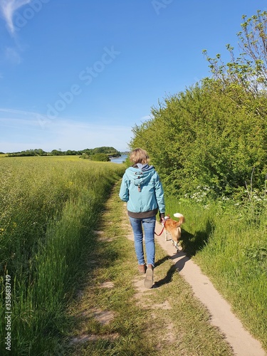 Junge Frau spaziert mit dem Hund an der Küste von Schleswig - Holstein © ralf werner froelich