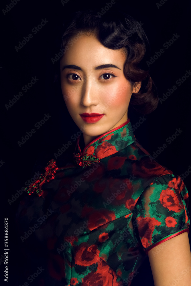 Asian woman wearing cheongsam in black background Asian woman wearing cheongsam in black background