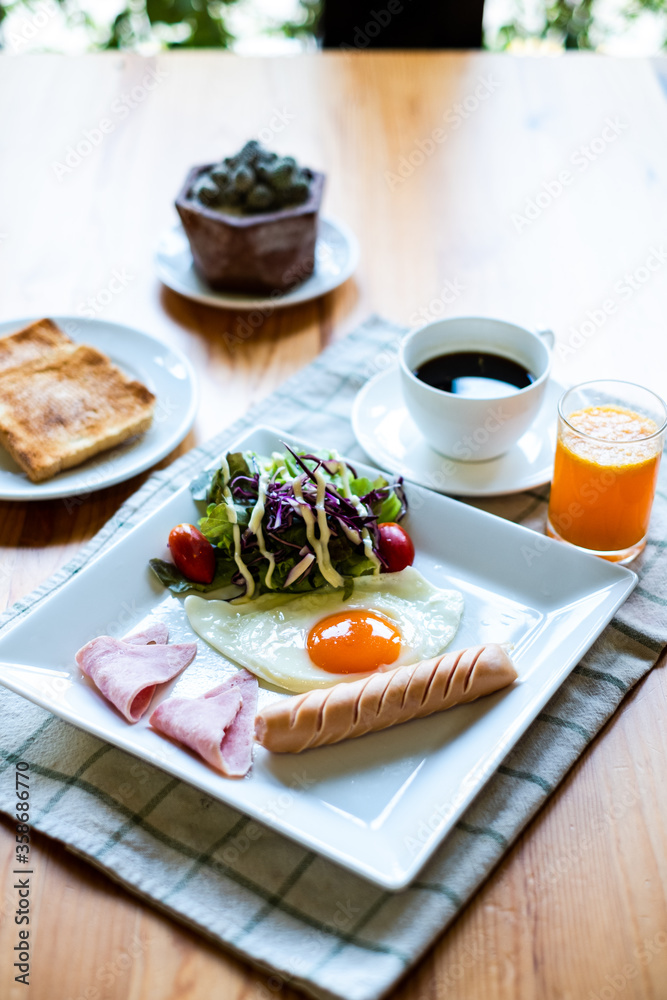 Breakfast or lunch with Fried egg, bread toast, green asparagus, tomatoes and bacon on black plate. Top view. Copy space. Banner. Breakfast or lunch with Fried egg, bread toast, green asparagus, tomatoes and bacon on black plate. Top view. Copy space. Banner.