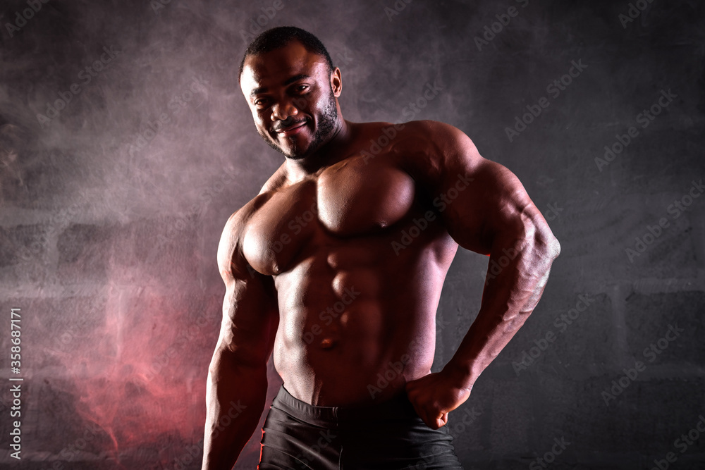 Close up of a bodybuilder. African American male athlete posing demonstrating abdominal muscles