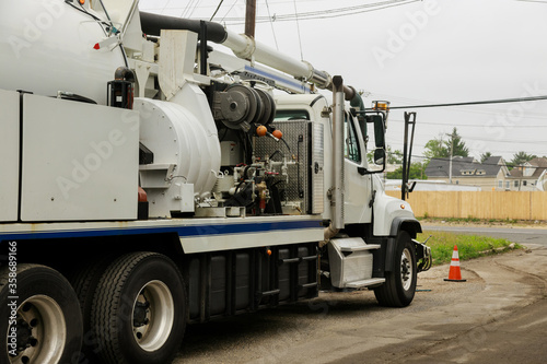 A specialized sewer cleaning machine works on a street.