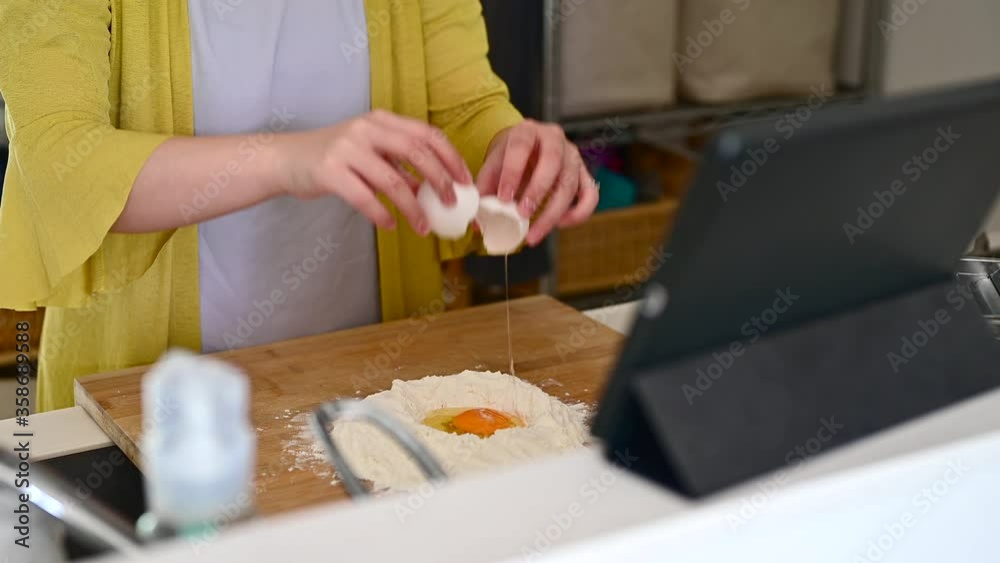 小麦粉の上に卵を落とす、パスタを作っている手元 小麦粉の上に卵を落とす、パスタを作っている手元