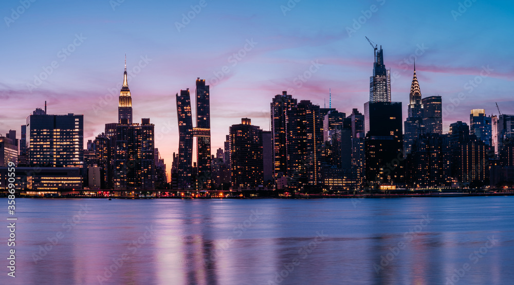 Obraz premium Widok na panoramę Manhattanu Midtown z Empire State Building, Chrysler Building, American Copper Buildings, Headquarters of the United Nations. Zdjęcie z długim czasem naświetlania