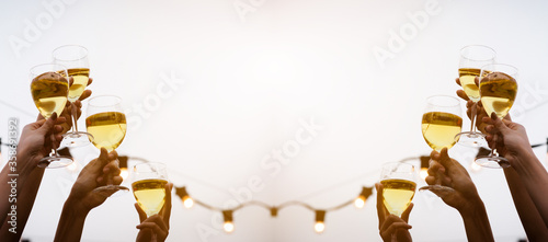 Tela Cheer! A group of people or friends cheering for champagne and blessing with party background, celebration concept, media size banner, Focus at the glass