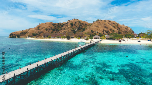 A wooden pier from the coast of Kanawa Island with turquoise sea in, Komodo National Park, Labuan Bajo, Indonesia photo