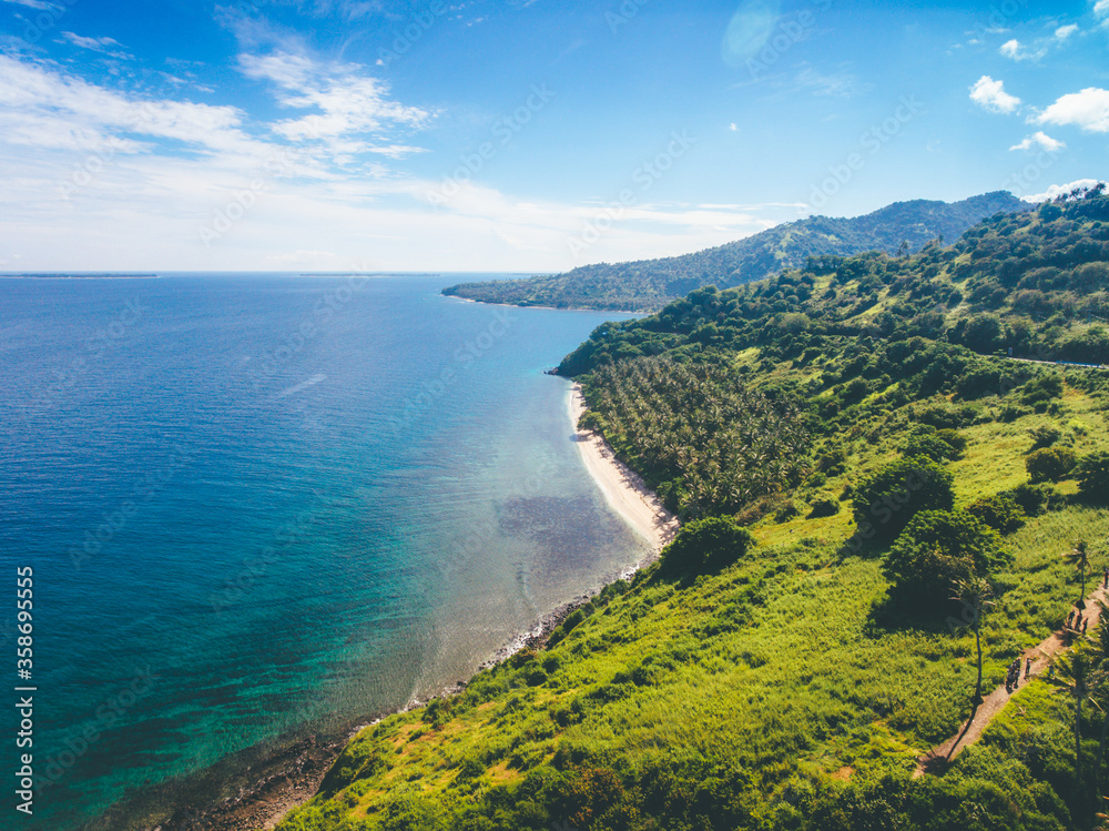 Aerial view of hill and sea. Beautiful landscape of Lombok Island, Indonesia. Nipah Hill in North Lombok with coconut trees