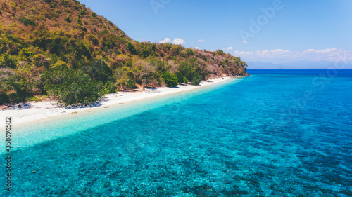 Aerial view of Poto Jarum Beach in Moyo Island, Sumbawa, Indonesia. Beautiful empty beach with with sand and crystal clear sea water