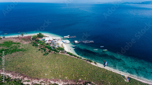 Aerial view of beautiful blue water of sea and the green island in Sumbawa, Indonesia