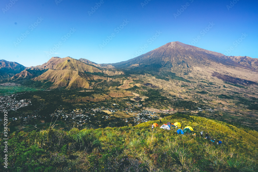 Fototapeta premium Pergasingan hill view with Mount Rinjani as the background in Lombok, Indonesia. Camping site.