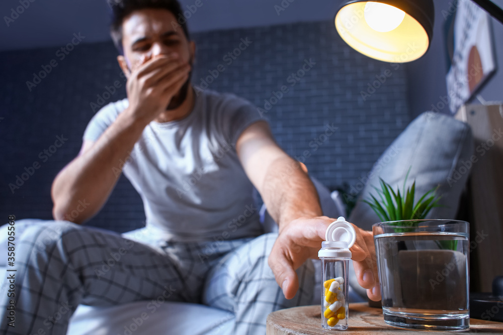 Man taking sleeping pills at night Man taking sleeping pills at night
